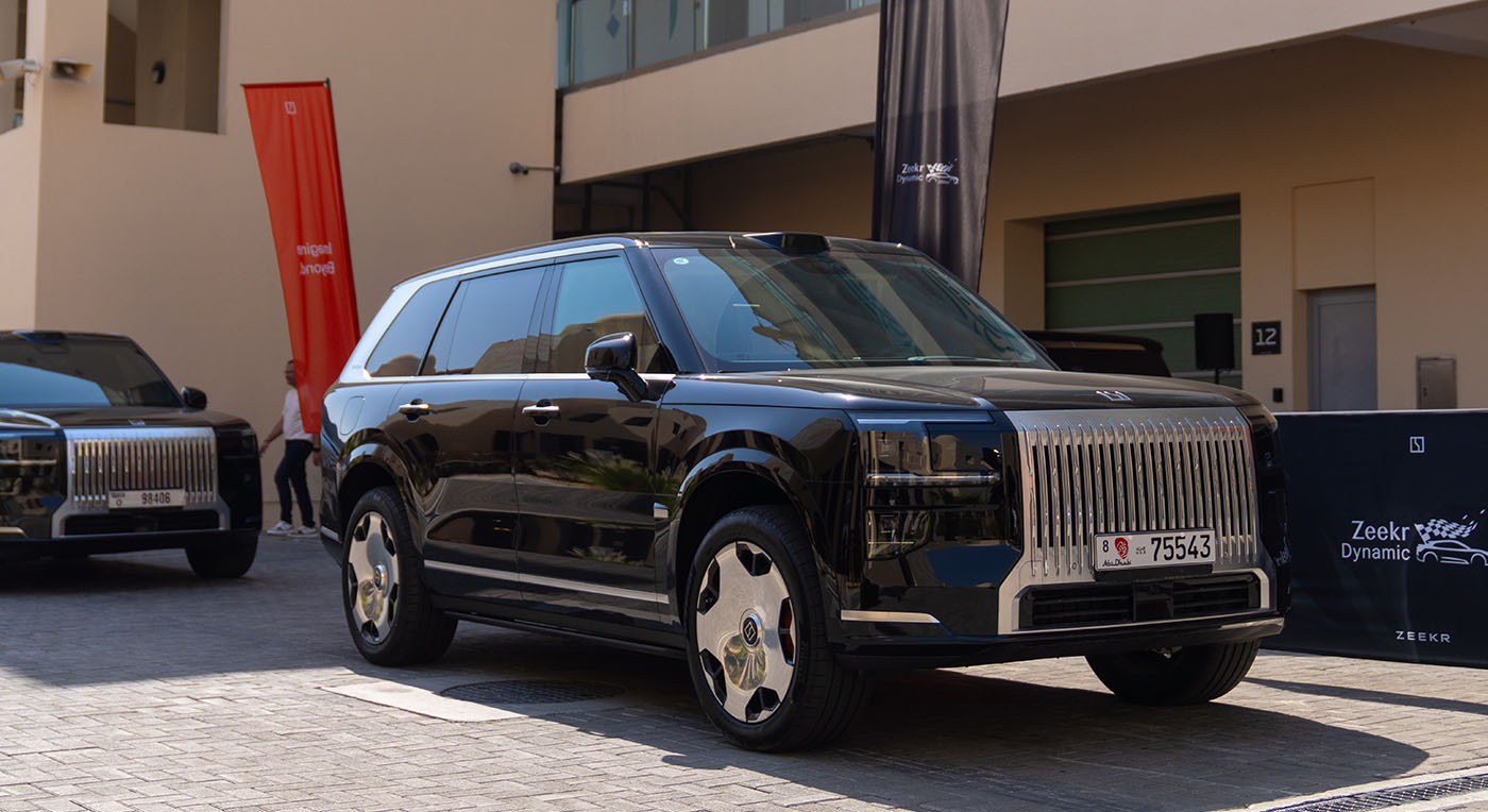 Front three-quarter view of a black luxury Zeekr 009 minivan featuring a massive vertical chrome grille.